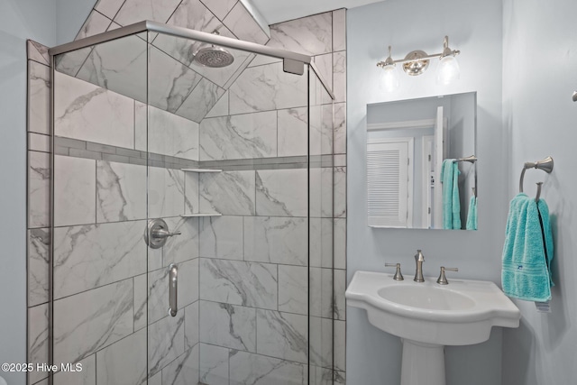 bathroom featuring a stall shower and a sink