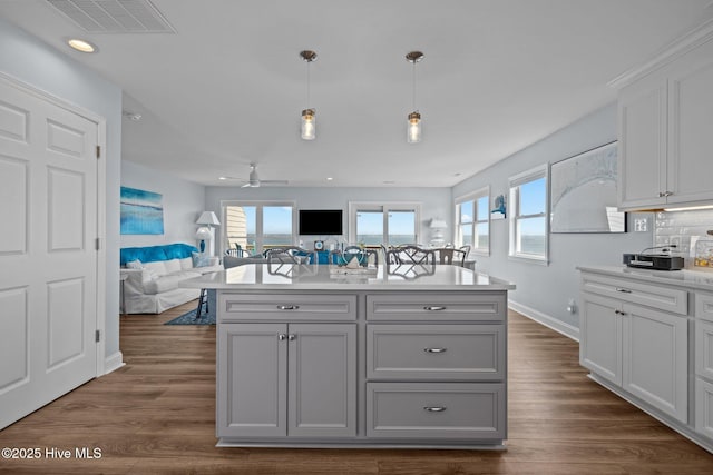 kitchen with gray cabinetry, light countertops, open floor plan, dark wood-style floors, and recessed lighting