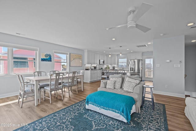 living area featuring a ceiling fan, recessed lighting, wood finished floors, and baseboards