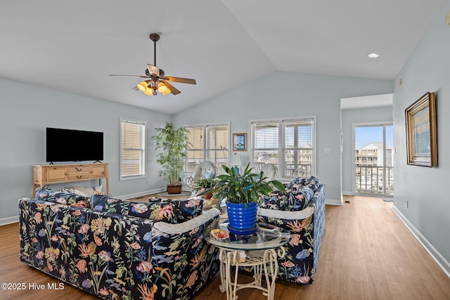 living room with wood finished floors, lofted ceiling, ceiling fan, and baseboards