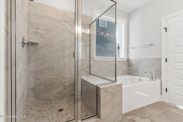 bathroom featuring a stall shower, a garden tub, and tile patterned flooring