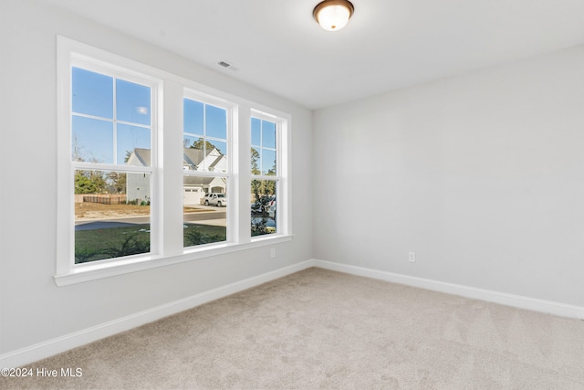 spare room featuring carpet and baseboards