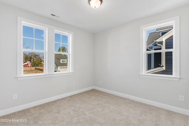 spare room featuring carpet floors and baseboards
