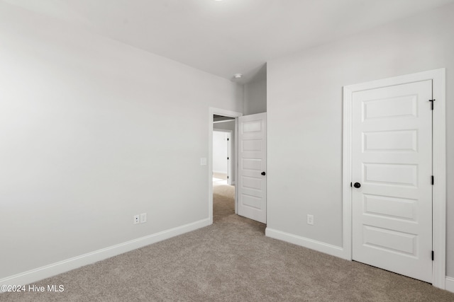 unfurnished bedroom featuring carpet and baseboards