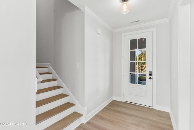 entryway with baseboards, ornamental molding, wood finished floors, and stairway