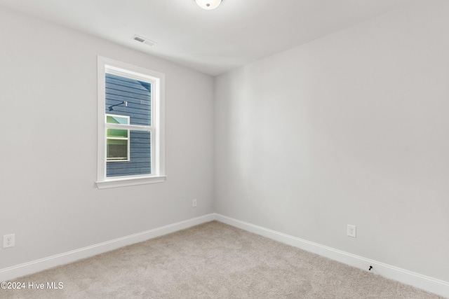 carpeted empty room featuring baseboards