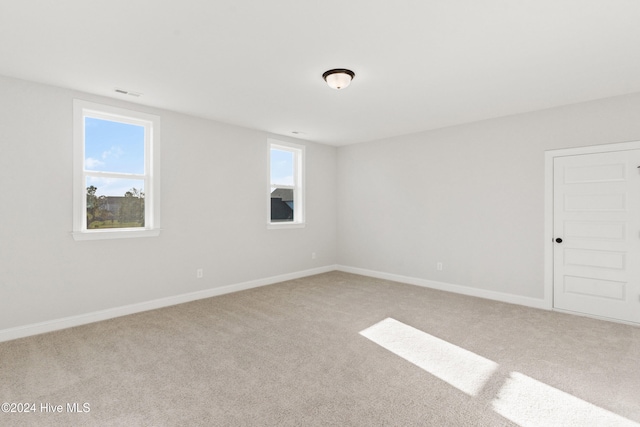 carpeted empty room with baseboards