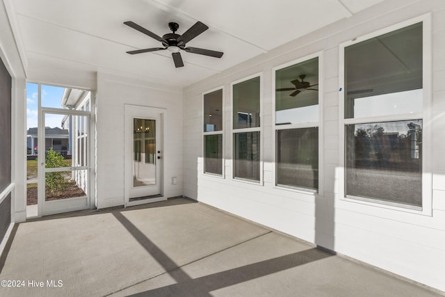unfurnished sunroom featuring a ceiling fan