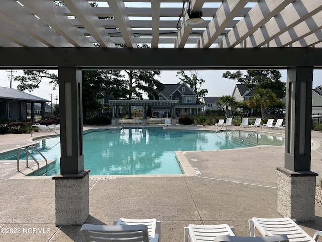 community pool with a pergola and a patio