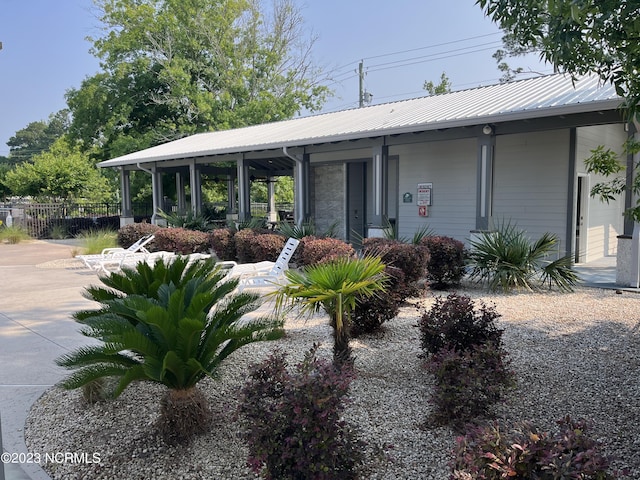 view of front of home with fence, metal roof, and covered porch