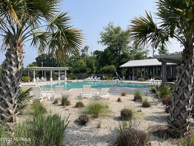 community pool with a pergola, fence, and a patio area