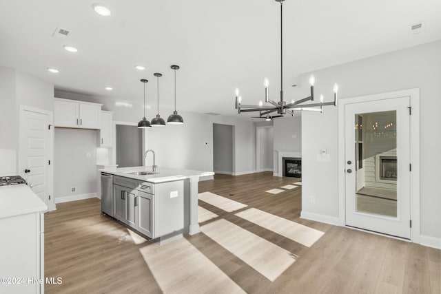 kitchen featuring a sink, light wood-type flooring, stainless steel dishwasher, and recessed lighting
