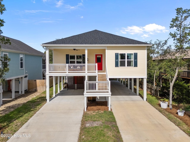 921 Whitecaps Ln, Carolina Beach, NC 28428 - coastal home with a carport, concrete driveway, ceiling fan, and covered porch