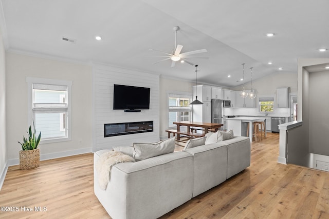 921 Whitecaps Ln, Carolina Beach, NC 28428 - living area with a ceiling fan, light wood finished floors, a large fireplace, healthy amount of natural light, and crown molding