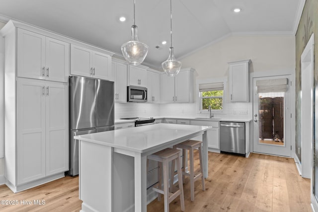 921 Whitecaps Ln, Carolina Beach, NC 28428 - kitchen featuring appliances with stainless steel finishes, crown molding, lofted ceiling, tasteful backsplash, and white cabinets