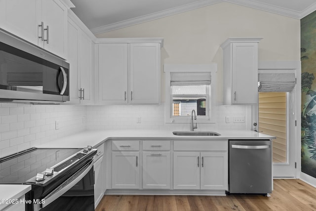 921 Whitecaps Ln, Carolina Beach, NC 28428 - kitchen featuring appliances with stainless steel finishes, a sink, white cabinetry, ornamental molding, and tasteful backsplash