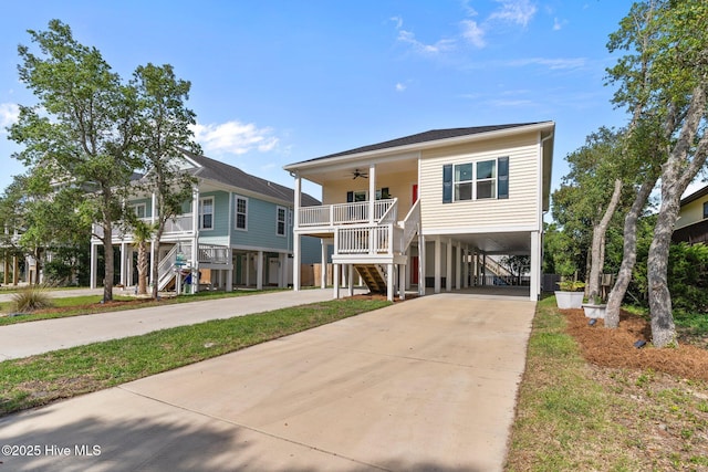 921 Whitecaps Ln, Carolina Beach, NC 28428 - coastal home with stairway, a ceiling fan, a carport, covered porch, and driveway