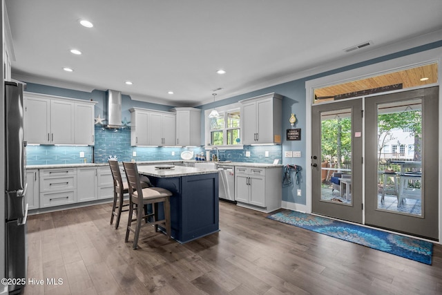 3528 Cordgrass Ln, Wilmington, NC 28409 - kitchen featuring stainless steel appliances, wall chimney range hood, decorative backsplash, recessed lighting, and a kitchen island