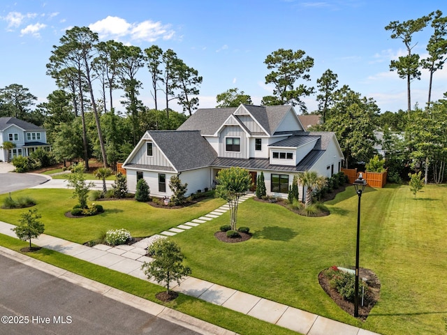 3528 Cordgrass Ln, Wilmington, NC 28409 - modern farmhouse featuring board and batten siding, a standing seam roof, metal roof, a front lawn, and roof with shingles