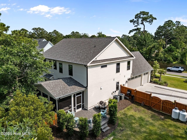 3528 Cordgrass Ln, Wilmington, NC 28409 - rear view of property with a shingled roof, a sunroom, a detached garage, and central AC unit