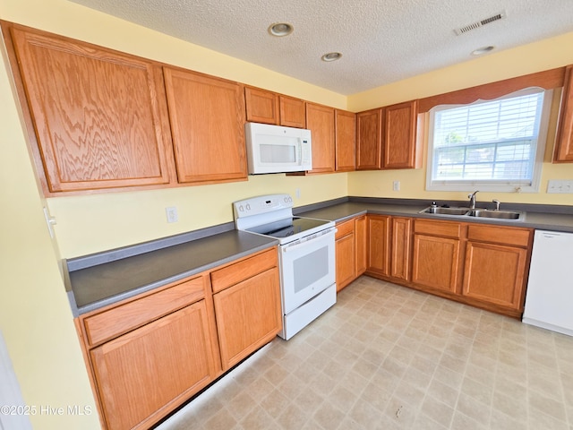 403 Mathew Andrew Ct, Swansboro, NC 28584 - kitchen featuring white appliances, a sink, a textured ceiling, light floors, and dark countertops