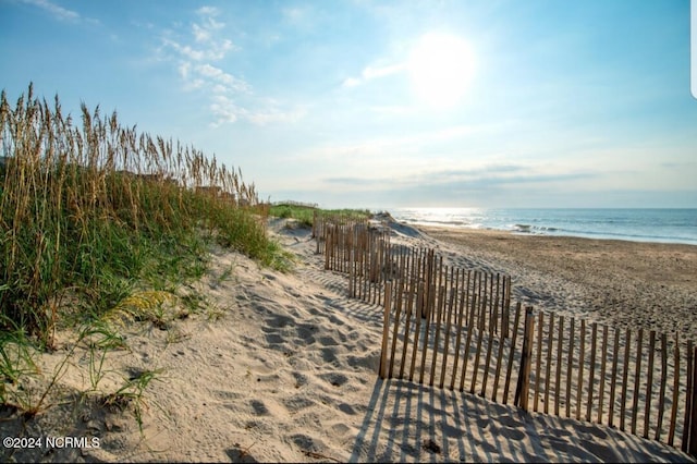 view of community featuring view of water and beach