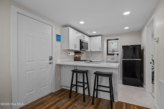 717 Cedar St Unit 1/2, Beaufort, NC 28516 - kitchen featuring freestanding refrigerator, stainless steel microwave, a sink, a peninsula, and dark wood-type flooring