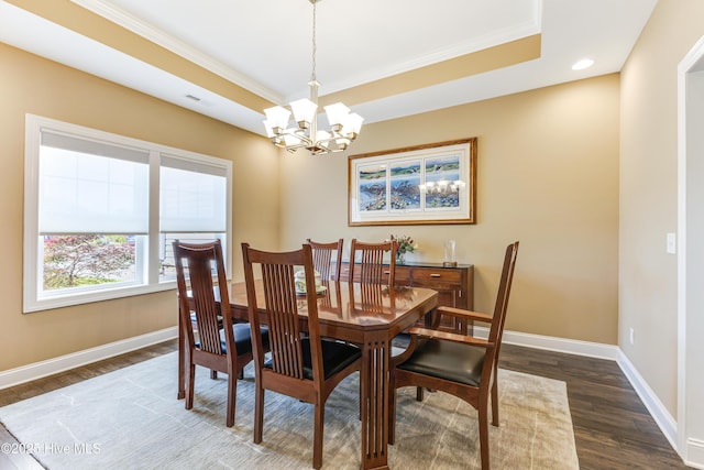 dining space featuring a chandelier, ornamental molding, baseboards, dark wood-type flooring, and a tray ceiling