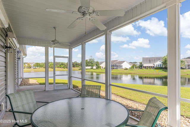 sunroom / solarium with ceiling fan, a water view, outdoor dining space, and a residential view