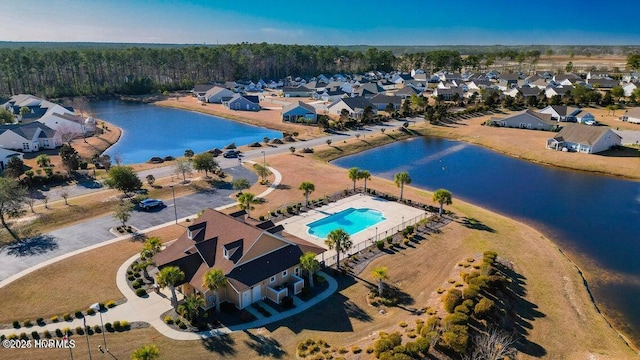aerial perspective of suburban area featuring a nearby body of water and a pool area