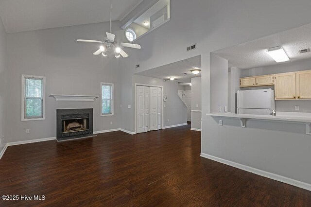 5126 Lamppost Cir, Wilmington, NC 28403 - unfurnished living room with dark wood-type flooring, ceiling fan, baseboards, a fireplace, and high vaulted ceiling