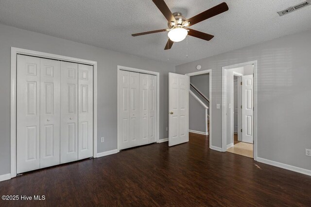5126 Lamppost Cir, Wilmington, NC 28403 - unfurnished bedroom featuring multiple closets, wood finished floors, baseboards, a textured ceiling, and a ceiling fan