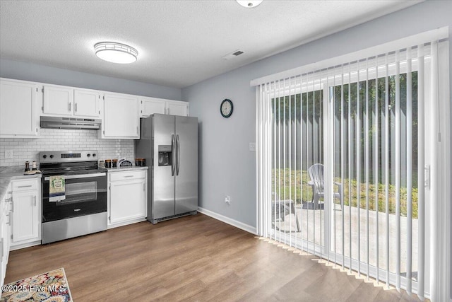 235 Zachary Ln, Hubert, NC 28539 - kitchen with stainless steel appliances, plenty of natural light, under cabinet range hood, backsplash, and a textured ceiling