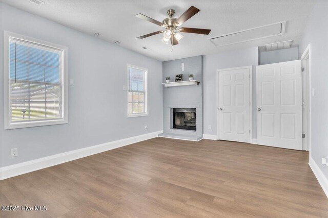 235 Zachary Ln, Hubert, NC 28539 - unfurnished living room with attic access, healthy amount of natural light, wood finished floors, and a large fireplace