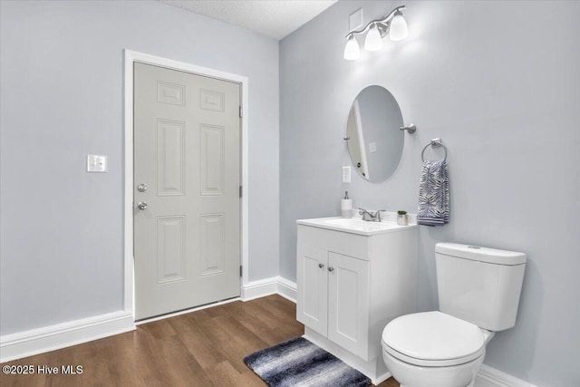 235 Zachary Ln, Hubert, NC 28539 - bathroom with wood finished floors, toilet, baseboards, and vanity