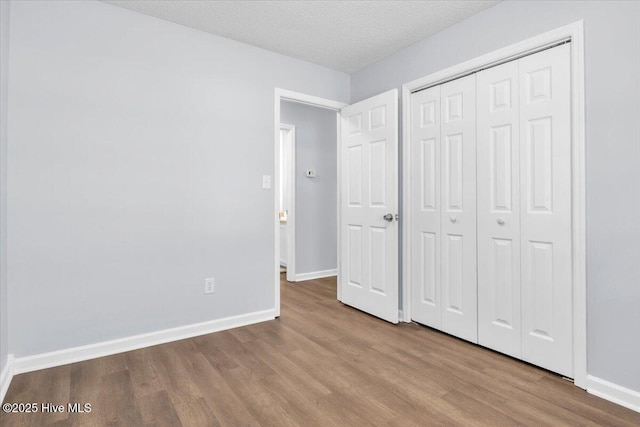 235 Zachary Ln, Hubert, NC 28539 - unfurnished bedroom featuring wood finished floors, baseboards, a closet, and a textured ceiling