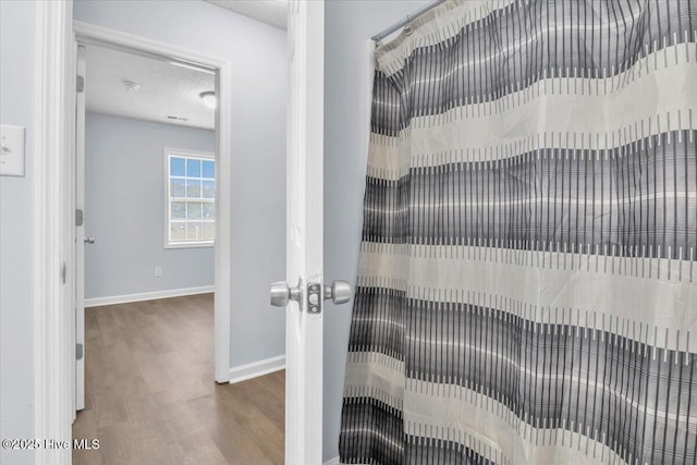 235 Zachary Ln, Hubert, NC 28539 - bathroom with wood finished floors, baseboards, a textured ceiling, and a shower with curtain