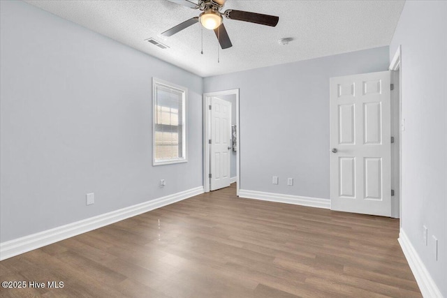 235 Zachary Ln, Hubert, NC 28539 - unfurnished bedroom featuring a textured ceiling, wood finished floors, baseboards, and a ceiling fan