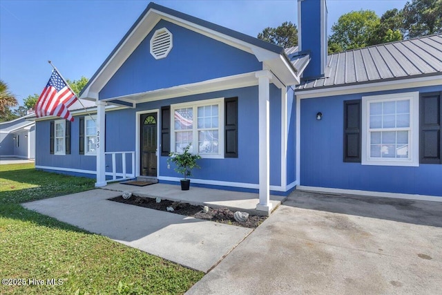 235 Zachary Ln, Hubert, NC 28539 - view of front of property featuring metal roof, covered porch, and a chimney