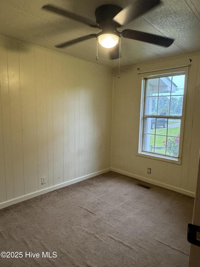 spare room with carpet and a ceiling fan