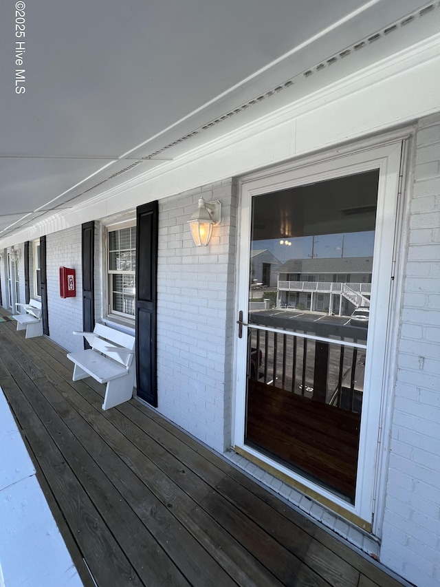 entrance to property featuring brick siding and a porch