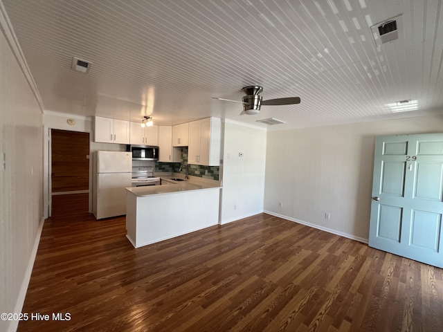 kitchen featuring white appliances, a sink, baseboards, dark wood finished floors, and a ceiling fan