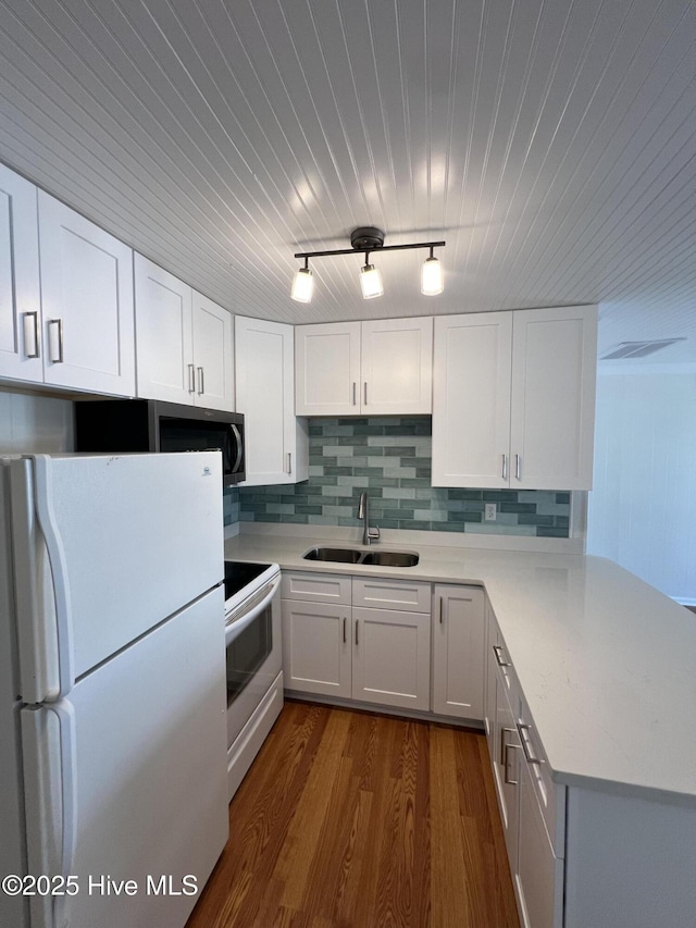kitchen with white appliances, a sink, light countertops, white cabinetry, and wood ceiling