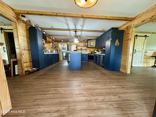 200 Wintergreen Patch Ln, Burnsville, NC 28714 - kitchen featuring a barn door, wooden walls, blue cabinets, wood finished floors, and light countertops