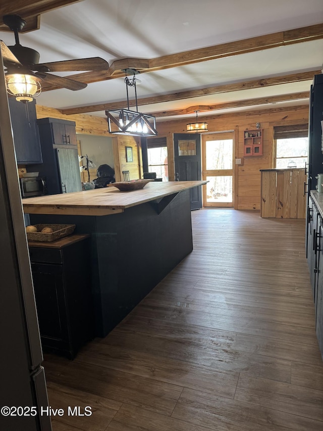 200 Wintergreen Patch Ln, Burnsville, NC 28714 - kitchen with beam ceiling, wooden walls, butcher block counters, dark wood-style flooring, and a ceiling fan
