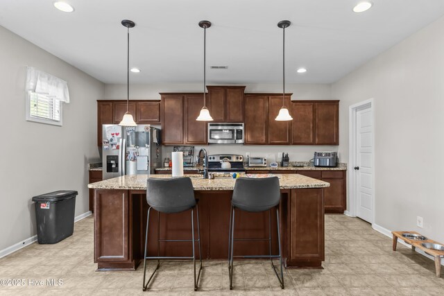 203 Holmes Point Ct, Jacksonville, NC 28546 - kitchen featuring appliances with stainless steel finishes, baseboards, a kitchen island with sink, recessed lighting, and light stone countertops