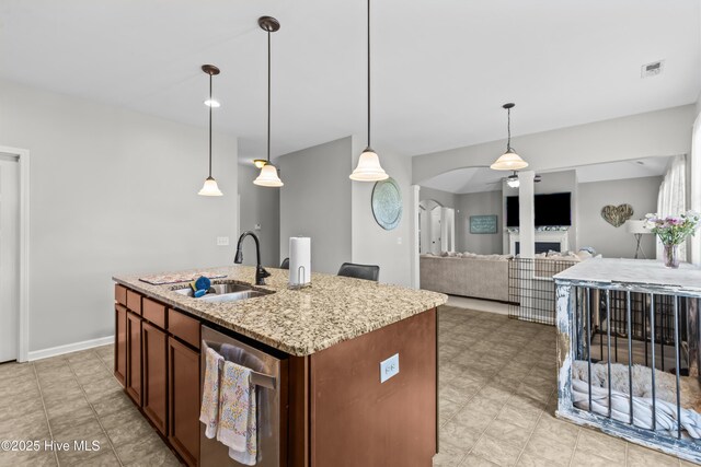 203 Holmes Point Ct, Jacksonville, NC 28546 - kitchen featuring a sink, stainless steel dishwasher, light stone counters, decorative light fixtures, and a center island with sink