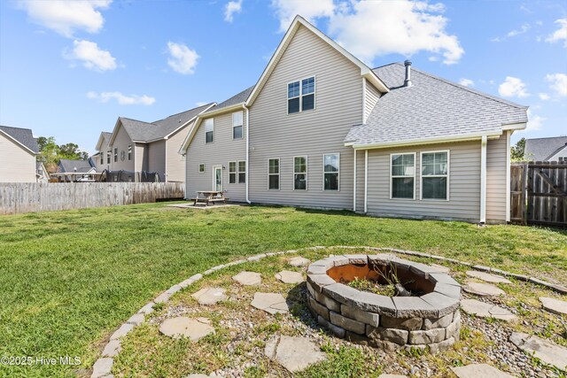 203 Holmes Point Ct, Jacksonville, NC 28546 - back of property with an outdoor fire pit, a patio, and a shingled roof