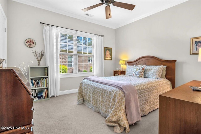 carpeted bedroom featuring crown molding, baseboards, and ceiling fan