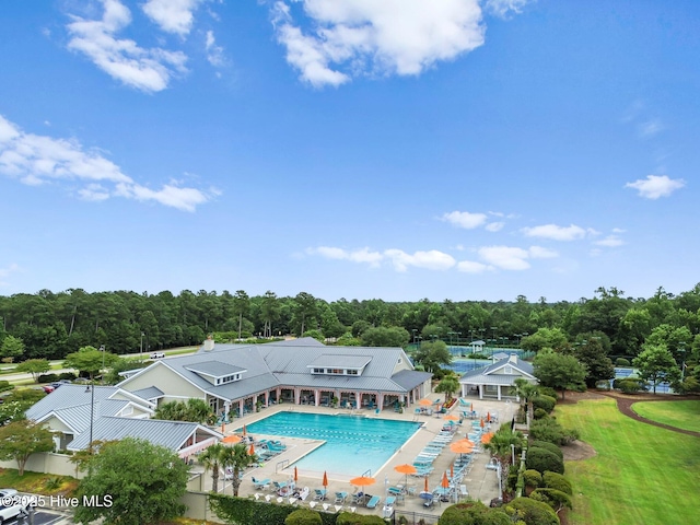 community pool with a patio and view of scattered trees